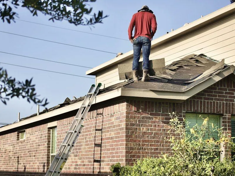 An old roof covering being stripped back to the deck